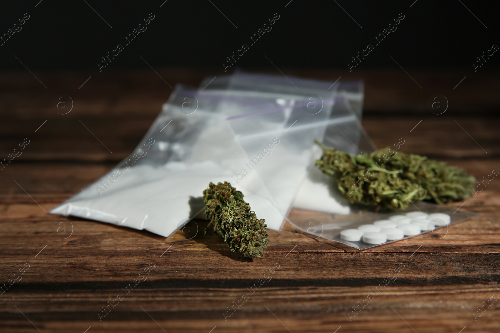 Photo of Cocaine, dried hemp and ecstasy on wooden table