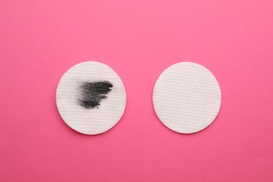 Photo of Clean and dirty cotton pads after removing makeup on pink background, flat lay