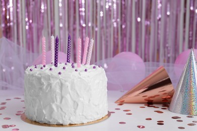 Photo of Delicious cake with candles and party hats on white table. Space for text