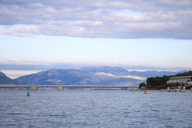 Photo of Picturesque view of mountains, town and bridge near sea