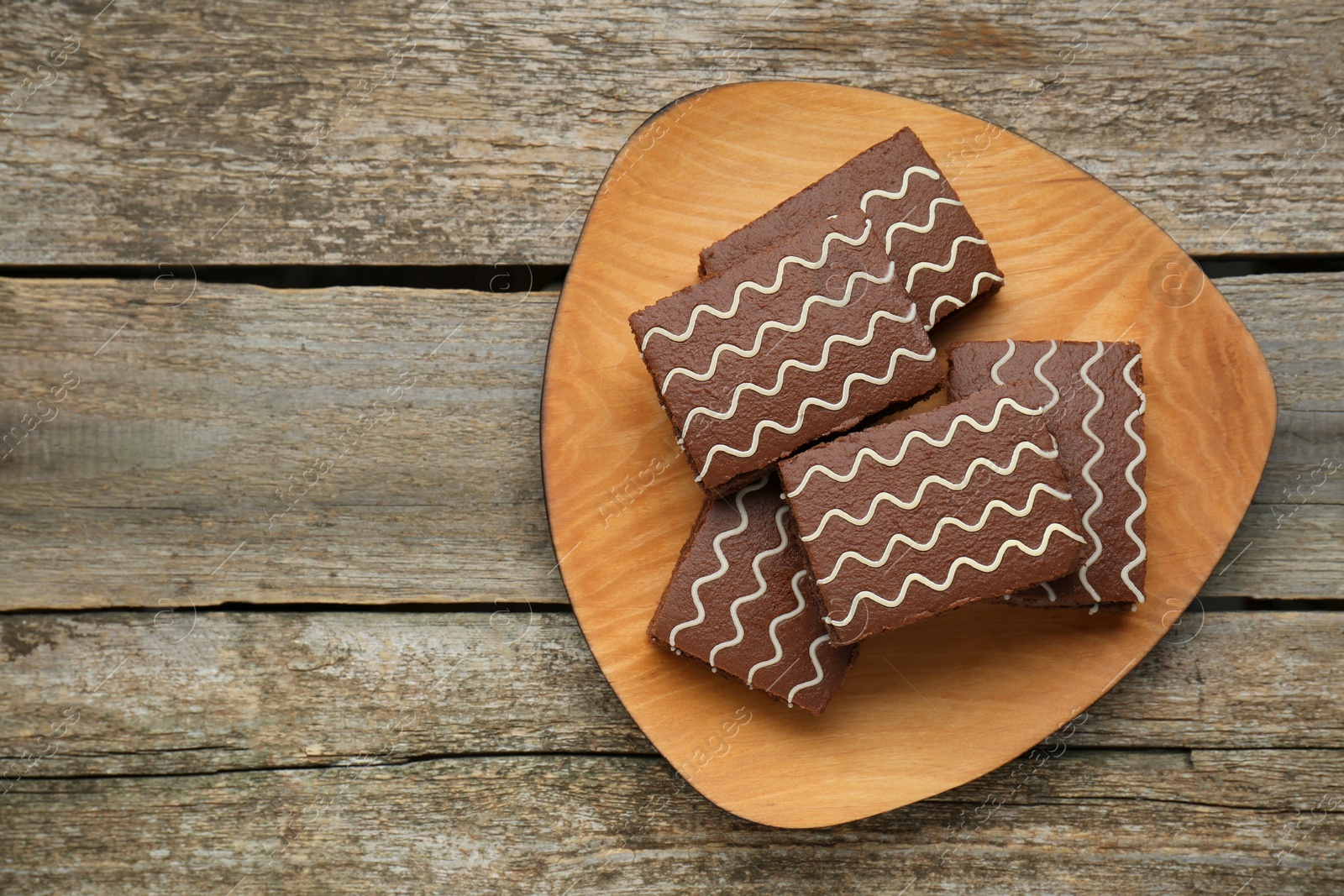 Photo of Tasty chocolate sponge cakes on wooden table, top view. Space for text