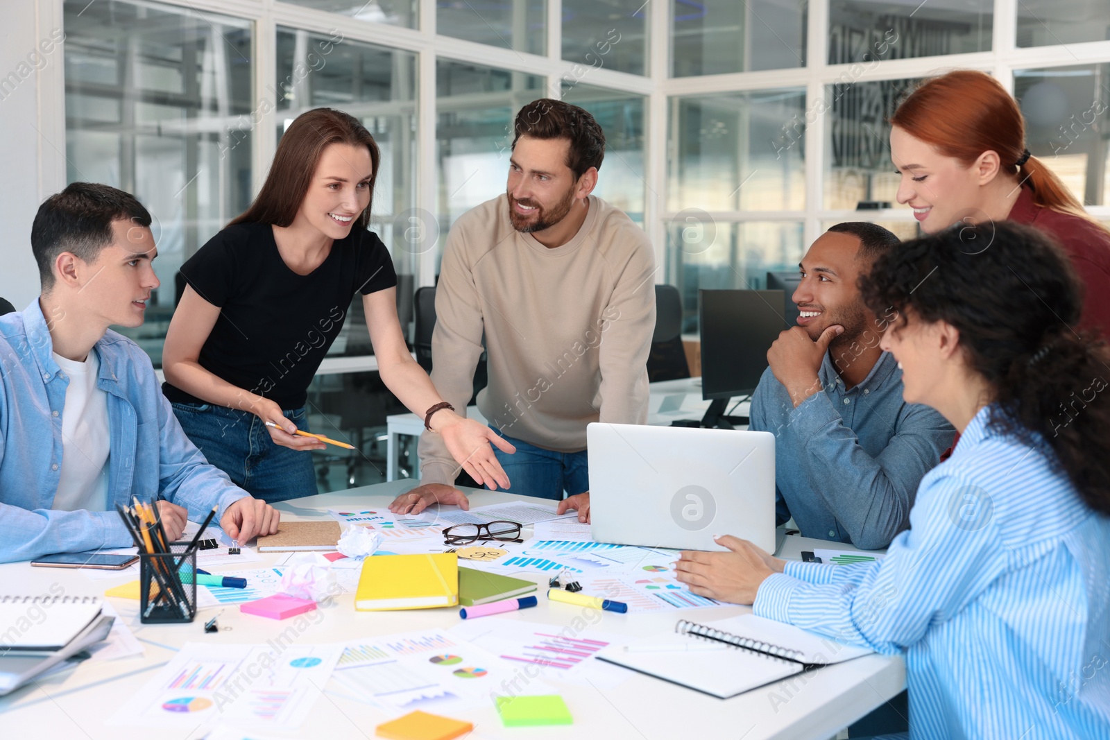 Photo of Team of employees working together at table in office. Startup project