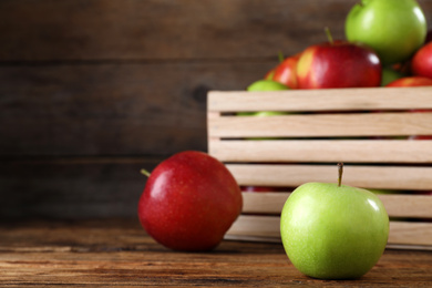 Composition with juicy apples on wooden table. Space for text