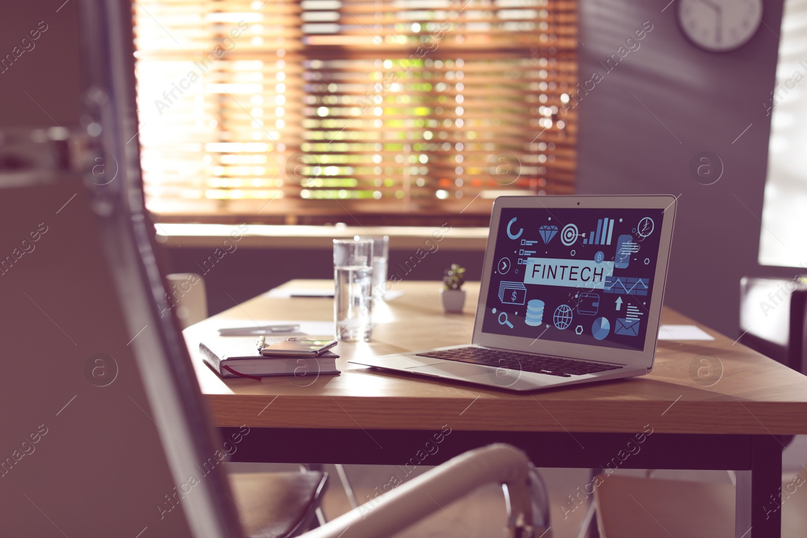 Image of Laptop with word FINTECH on wooden table in modern office