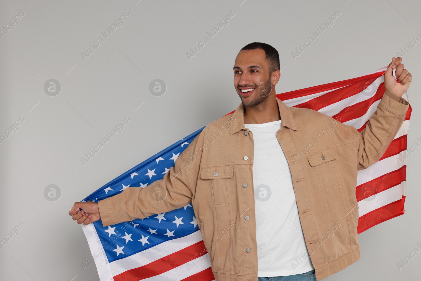 Photo of 4th of July - Independence Day of USA. Happy man with American flag on light grey background