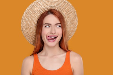 Photo of Happy woman showing her tongue on orange background