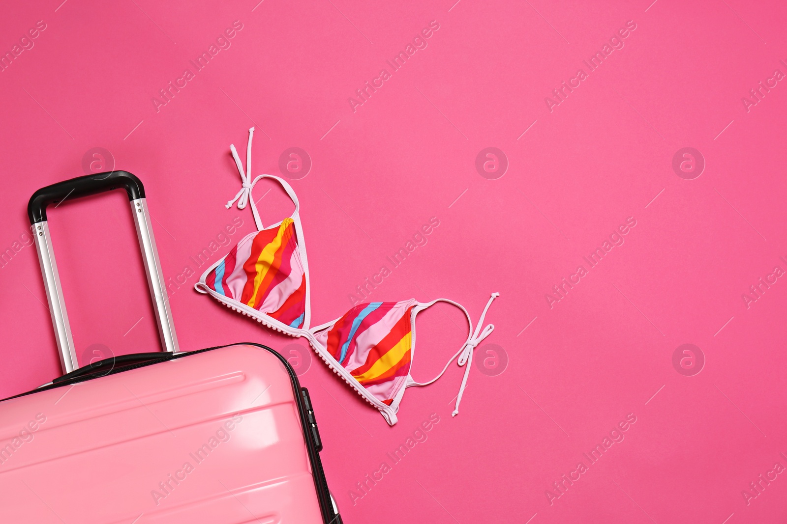 Photo of Stylish suitcase, bikini top and space for text on color background, top view