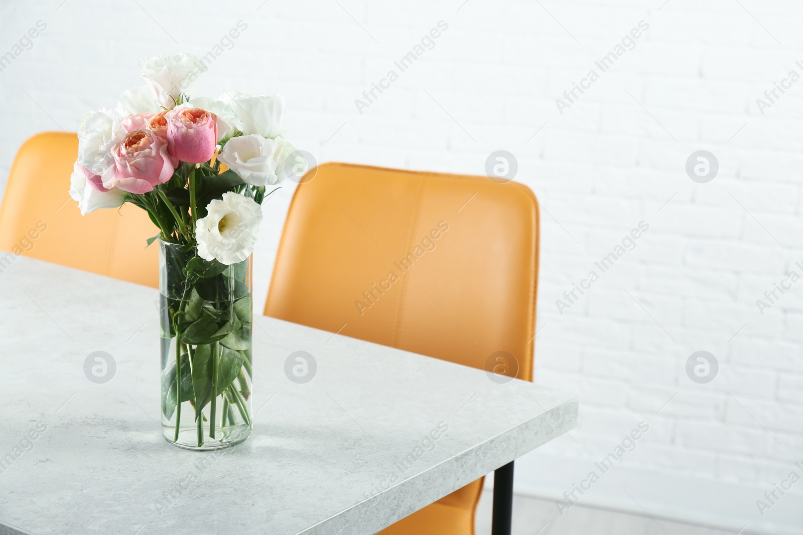 Photo of Vase with beautiful flowers as element of interior design on table in room. Space for text