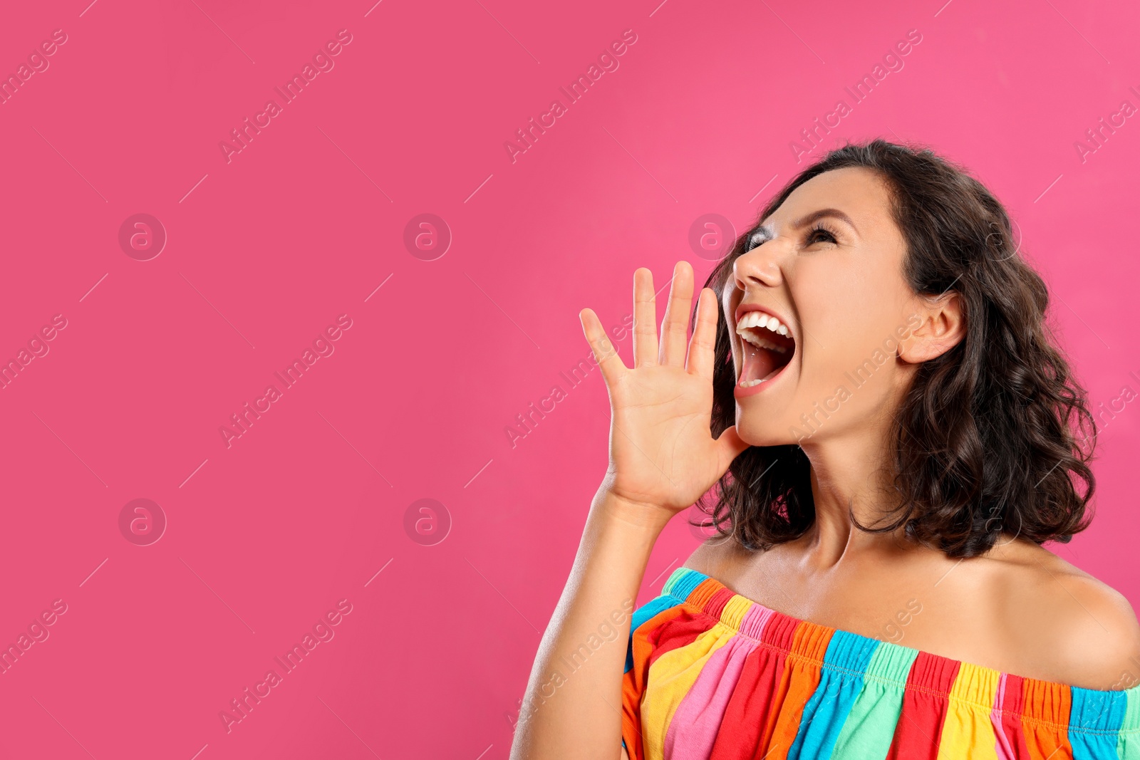 Photo of Beautiful young woman screaming on pink background. Space for text