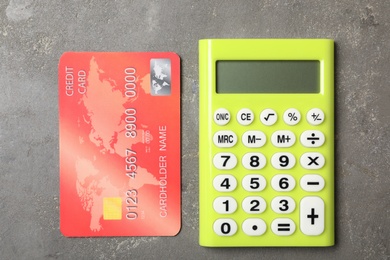 Credit card and calculator on grey background, flat lay