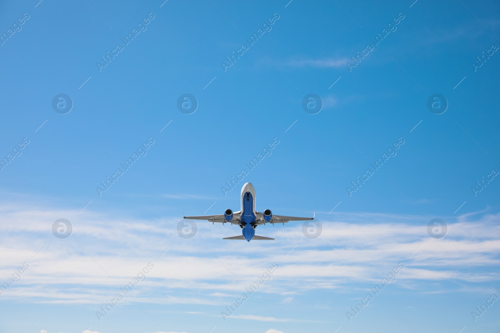 Photo of Modern white airplane flying in sky, low angle view