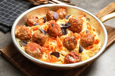 Photo of Delicious pasta with meatballs and tomato sauce in frying pan