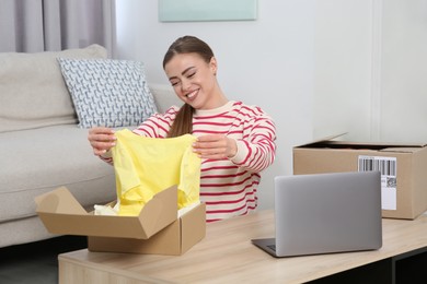 Photo of Happy woman unpacking parcels at home. Online store