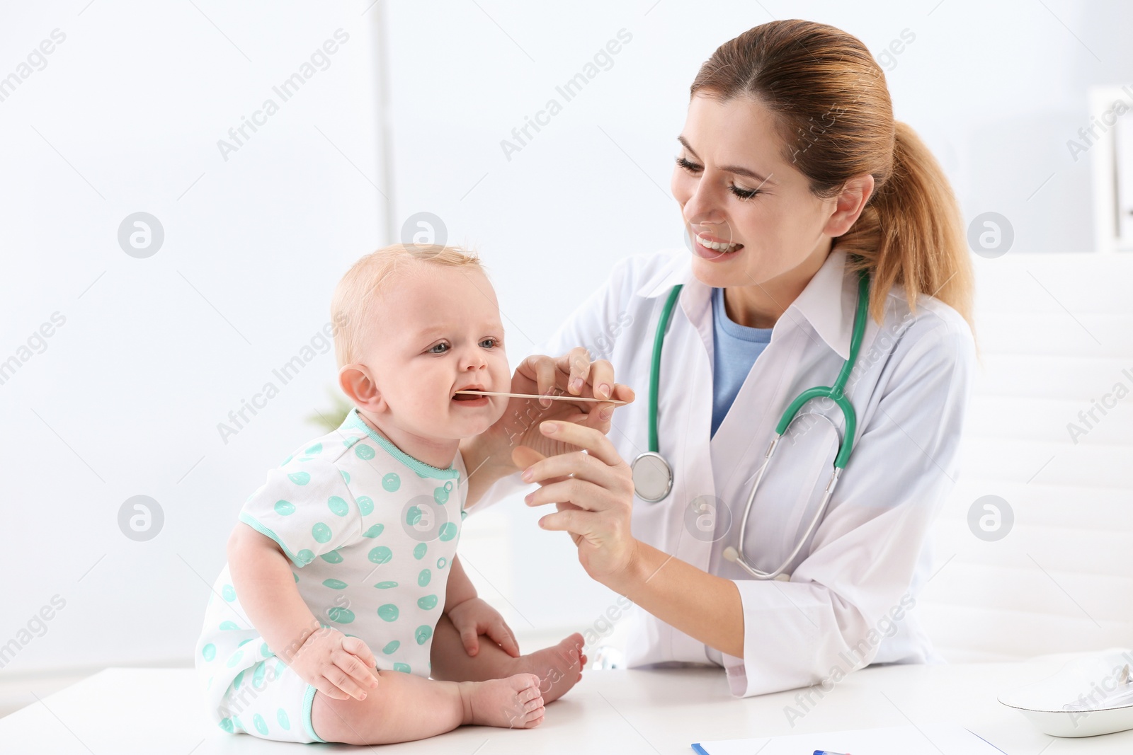 Photo of Children's doctor examining baby's throat in hospital