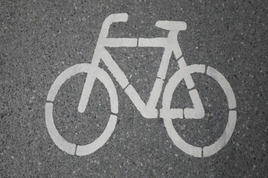 Photo of Bicycle lane with white sign painted on asphalt, top view