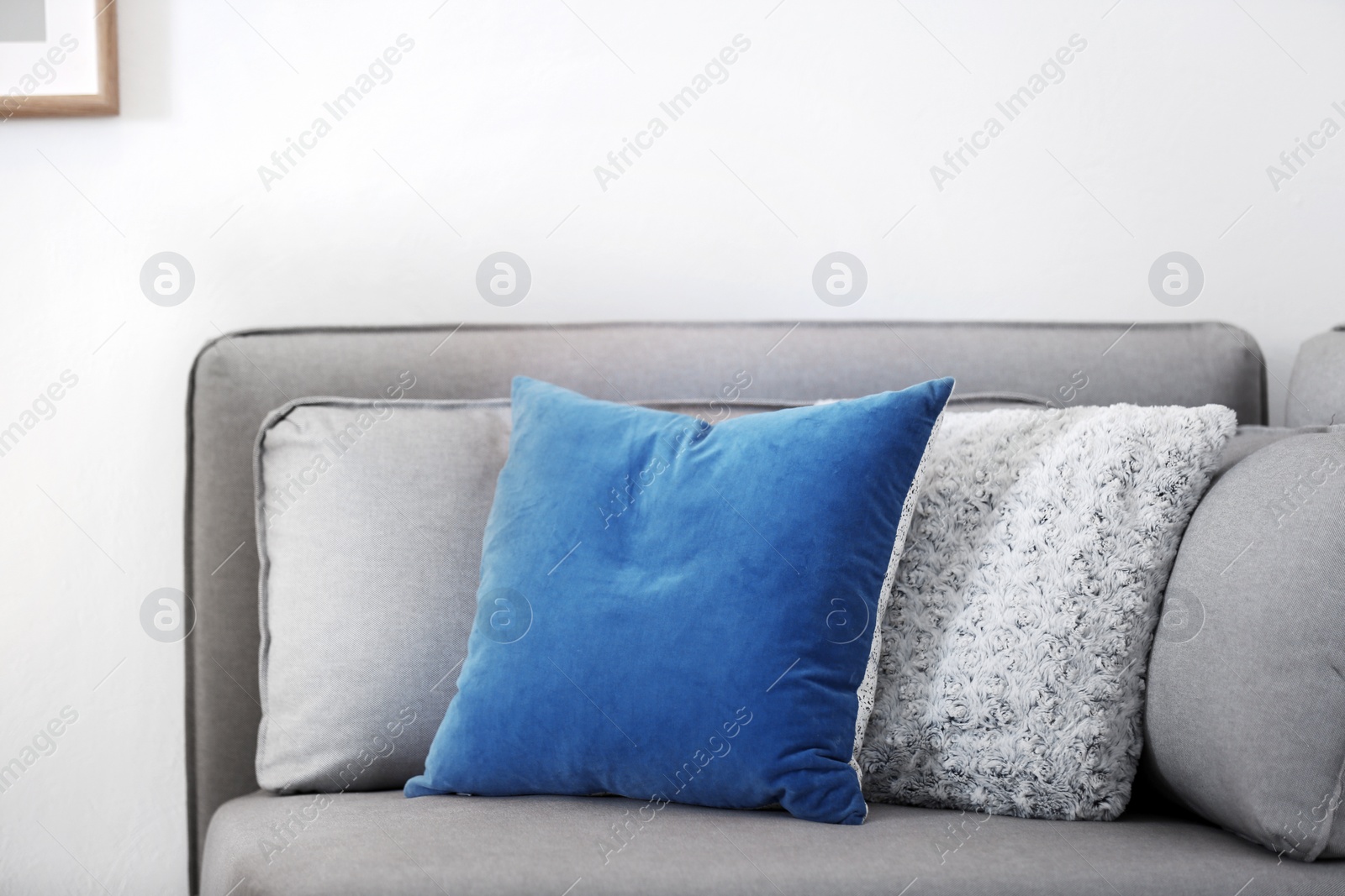 Photo of Different soft pillows on sofa in room. Interior element
