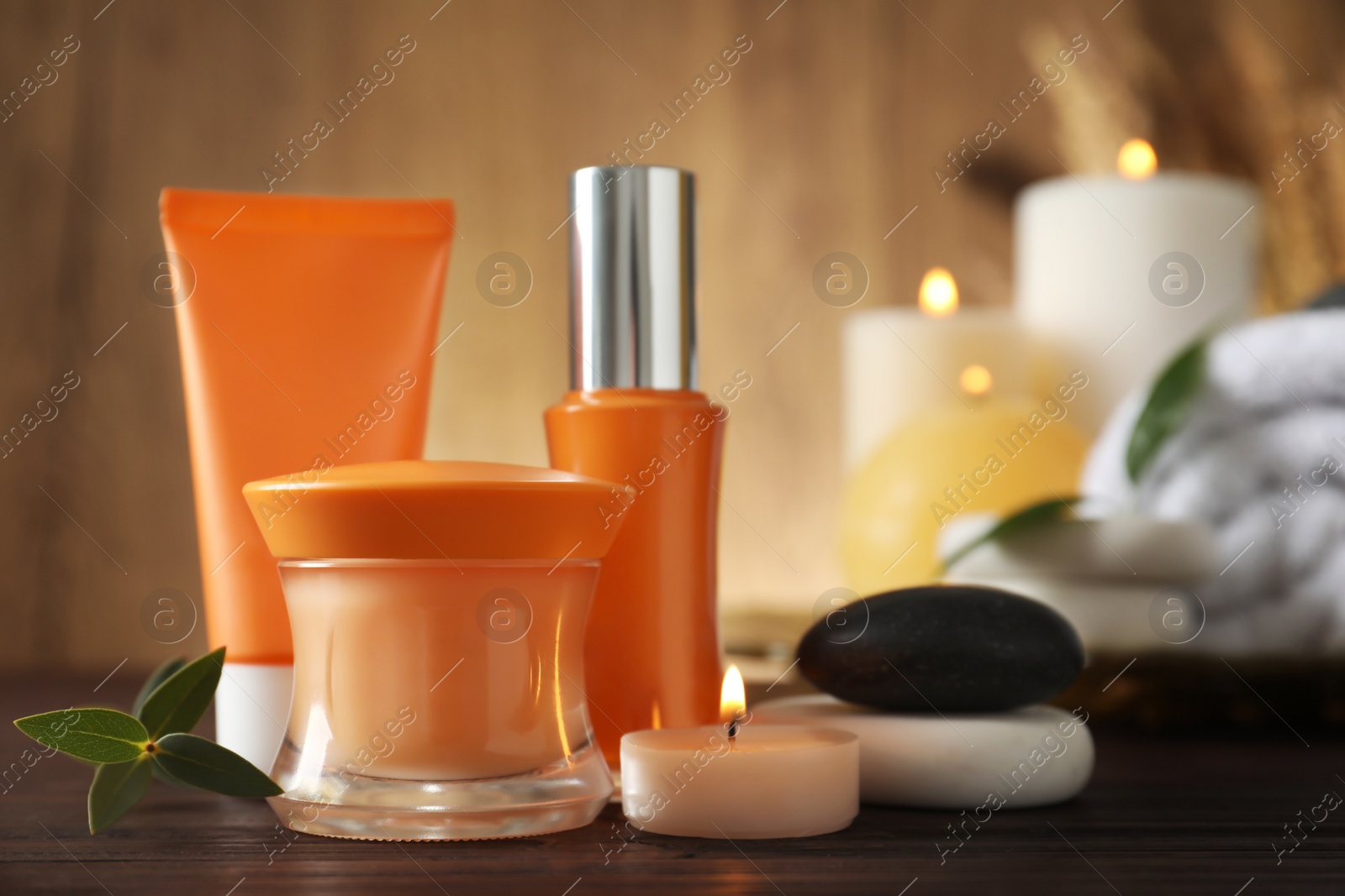 Photo of Composition with cosmetic products and spa stones on wooden table. Space for text