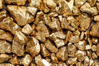 Pile of gold nuggets as background, top view