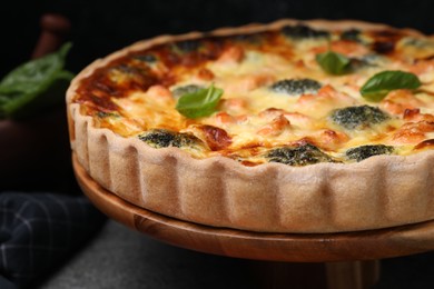 Photo of Delicious homemade quiche with salmon and broccoli on wooden board, closeup