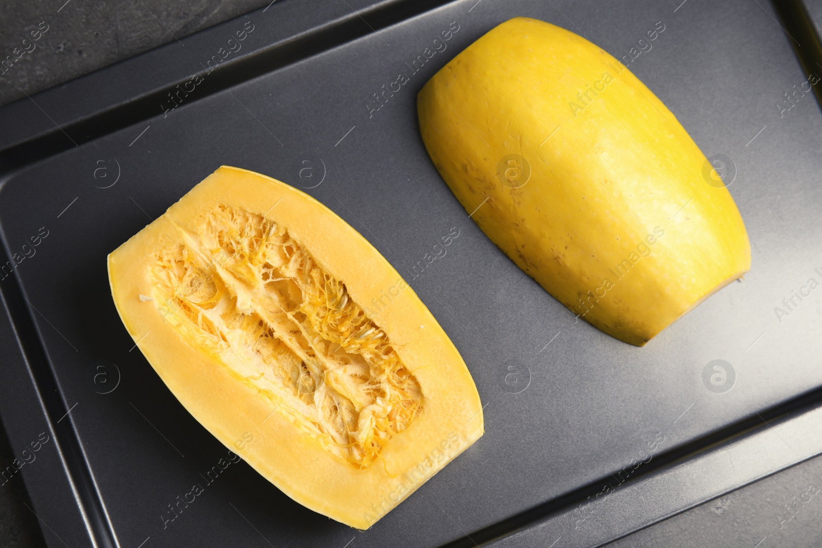 Photo of Baking tray with cut spaghetti squash on table