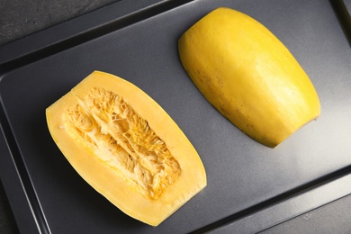 Photo of Baking tray with cut spaghetti squash on table