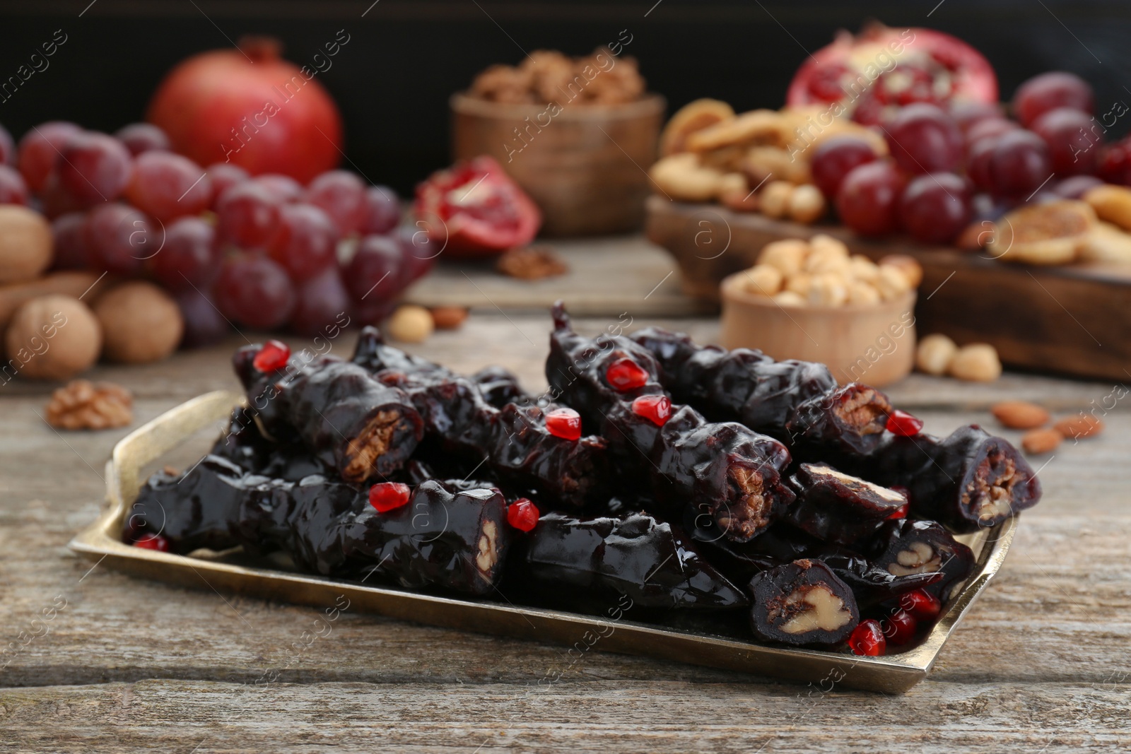 Photo of Tray with delicious sweet churchkhelas on wooden table