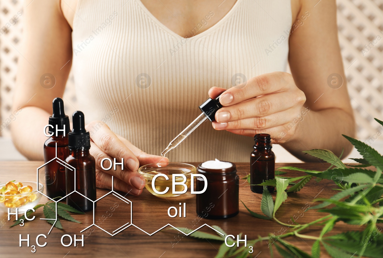 Image of Woman dripping CBD oil into bowl at wooden table, closeup