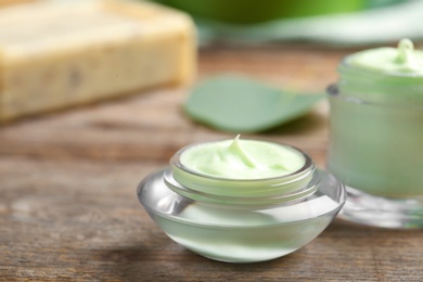 Photo of Closeup view of hand cream jar on wooden background