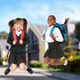 Image of Happy girls jumping near house. School holidays