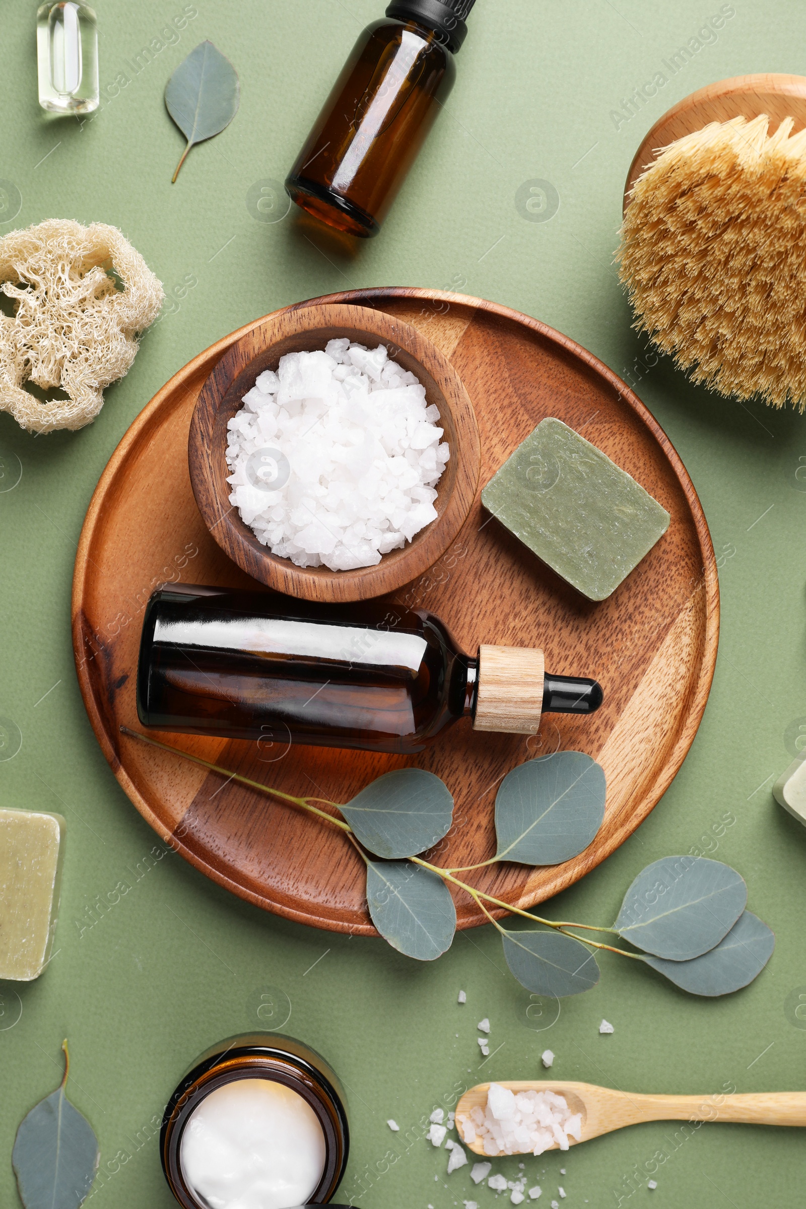 Photo of Flat lay composition with different spa products and eucalyptus branches on olive background