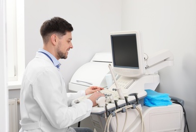 Sonographer operating modern ultrasound machine in clinic