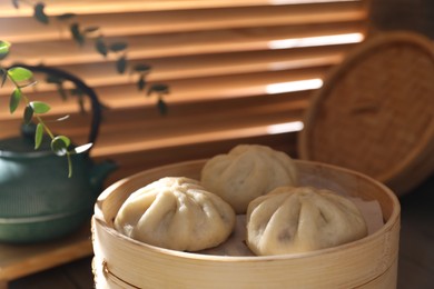 Photo of Delicious bao buns (baozi) on table, closeup