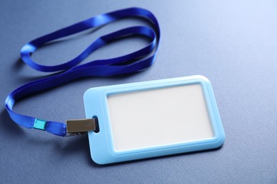 Photo of Blank badge with string on blue background, closeup