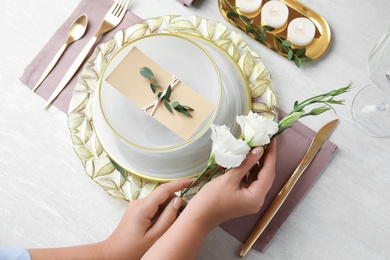 Woman setting table for festive dinner, closeup