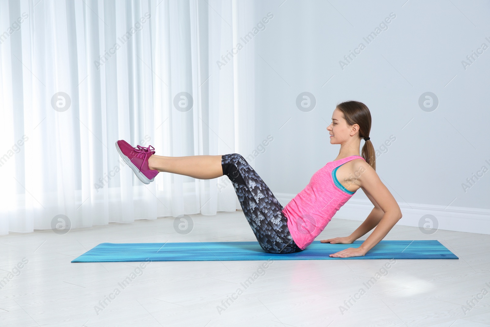 Photo of Young woman doing fitness exercises at home
