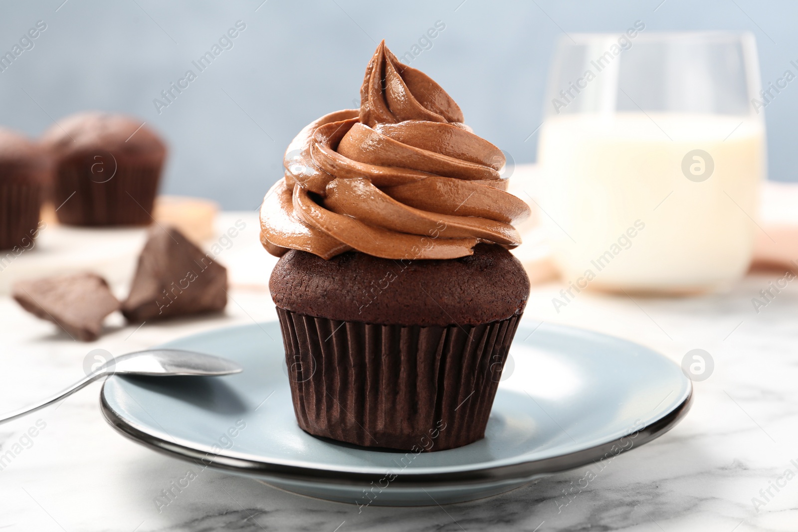 Photo of Delicious fresh chocolate cupcake on white marble table, closeup