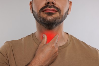 Image of Endocrine system. Man doing thyroid self examination on light grey background, closeup
