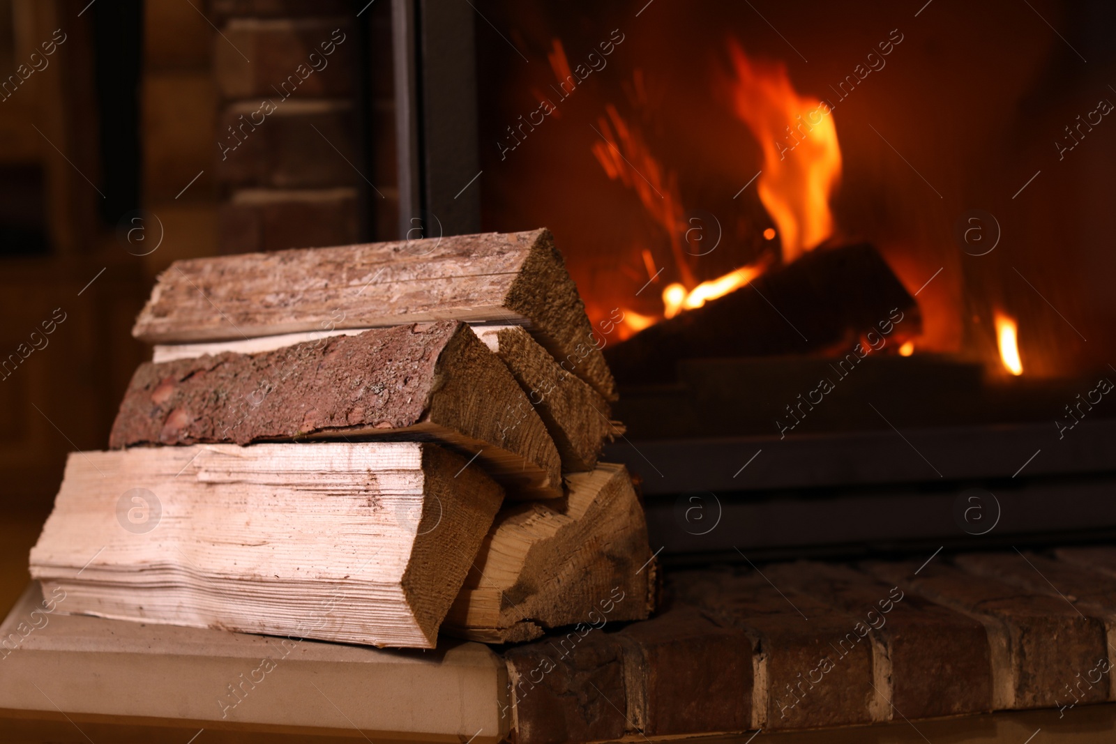 Photo of Pile of wood near fireplace indoors. Winter vacation