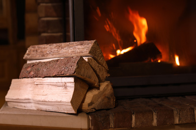 Photo of Pile of wood near fireplace indoors. Winter vacation