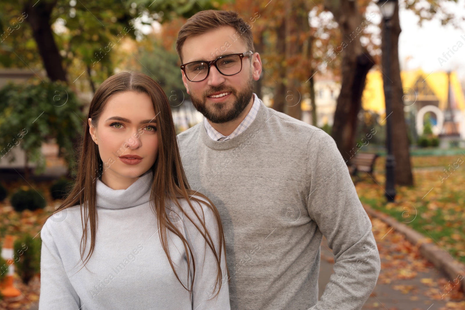 Photo of Happy couple wearing stylish clothes in autumn park