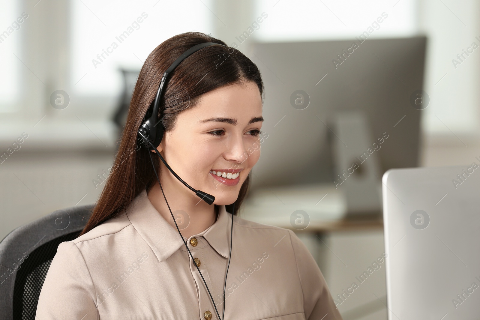 Photo of Hotline operator with headset working on computer in office