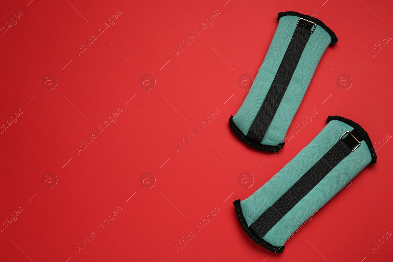 Photo of Turquoise weighting agents on red background, flat lay. Space for text