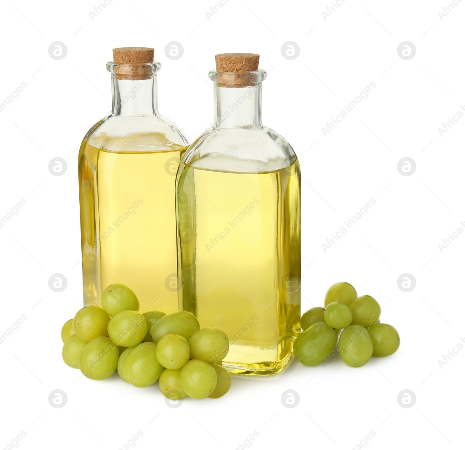 Photo of Vegetable fats. Bottles of cooking oils and fresh grapes isolated on white