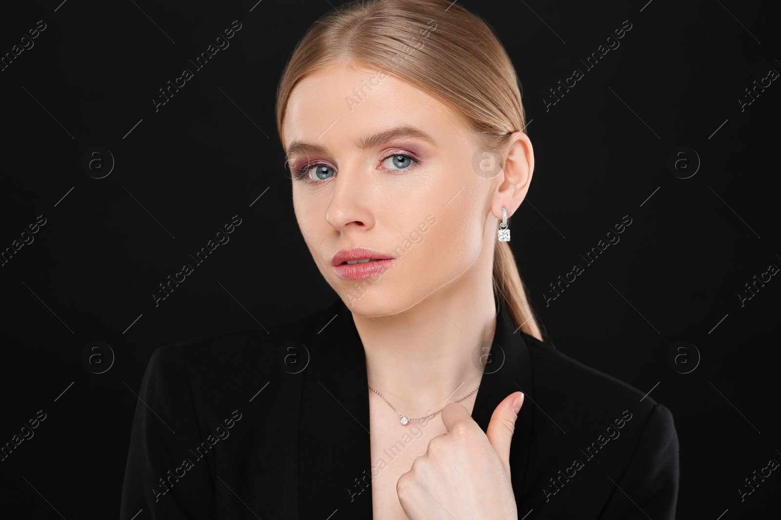 Photo of Beautiful young woman with elegant jewelry on black background