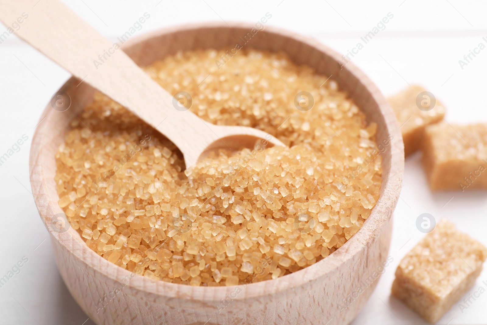 Photo of Brown sugar and spoon in bowl on table, closeup