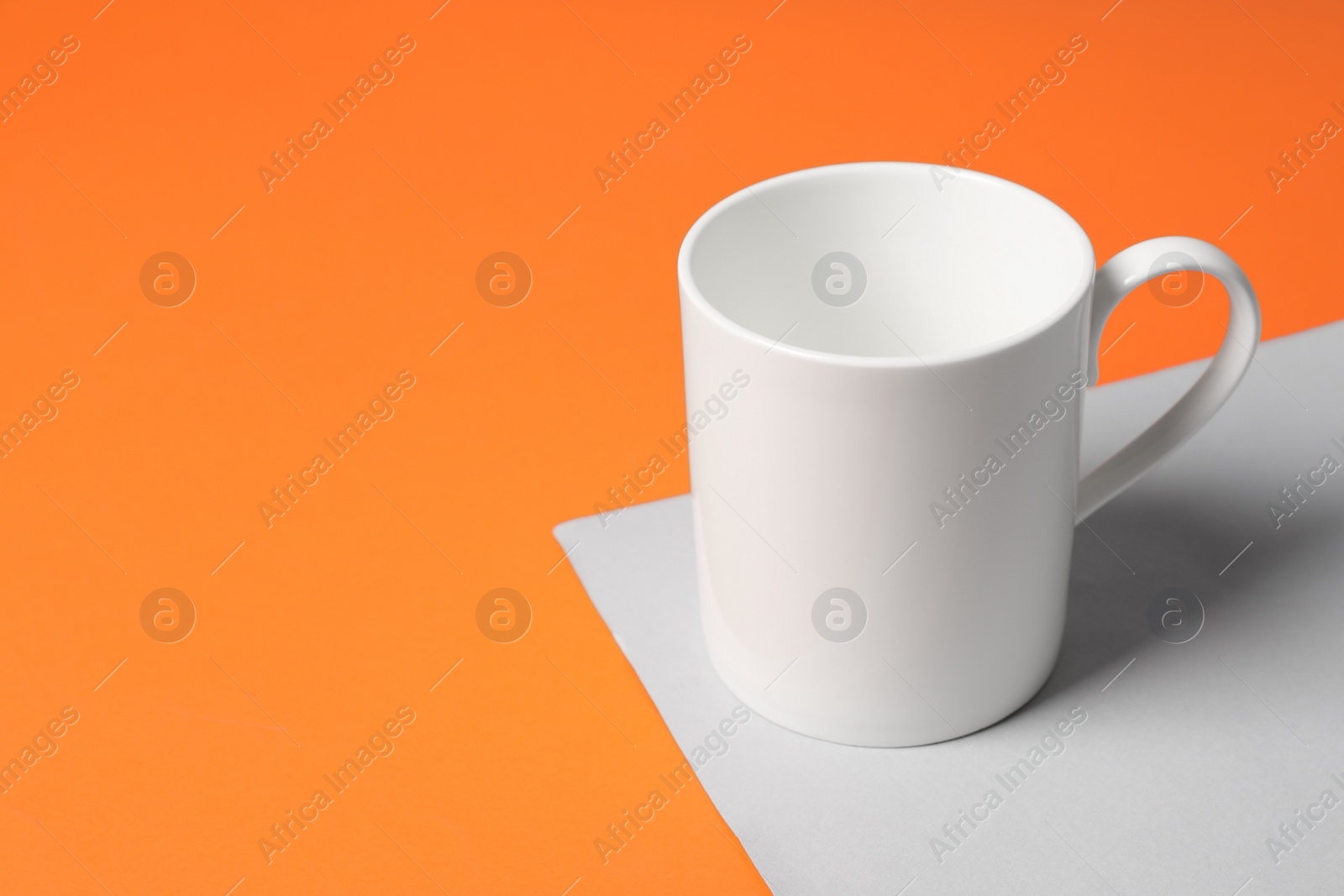 One white ceramic mug on color background, space for text Photo of One white ceramic mug on color background, space for text
