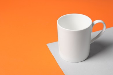 Photo of One white ceramic mug on color background, space for text