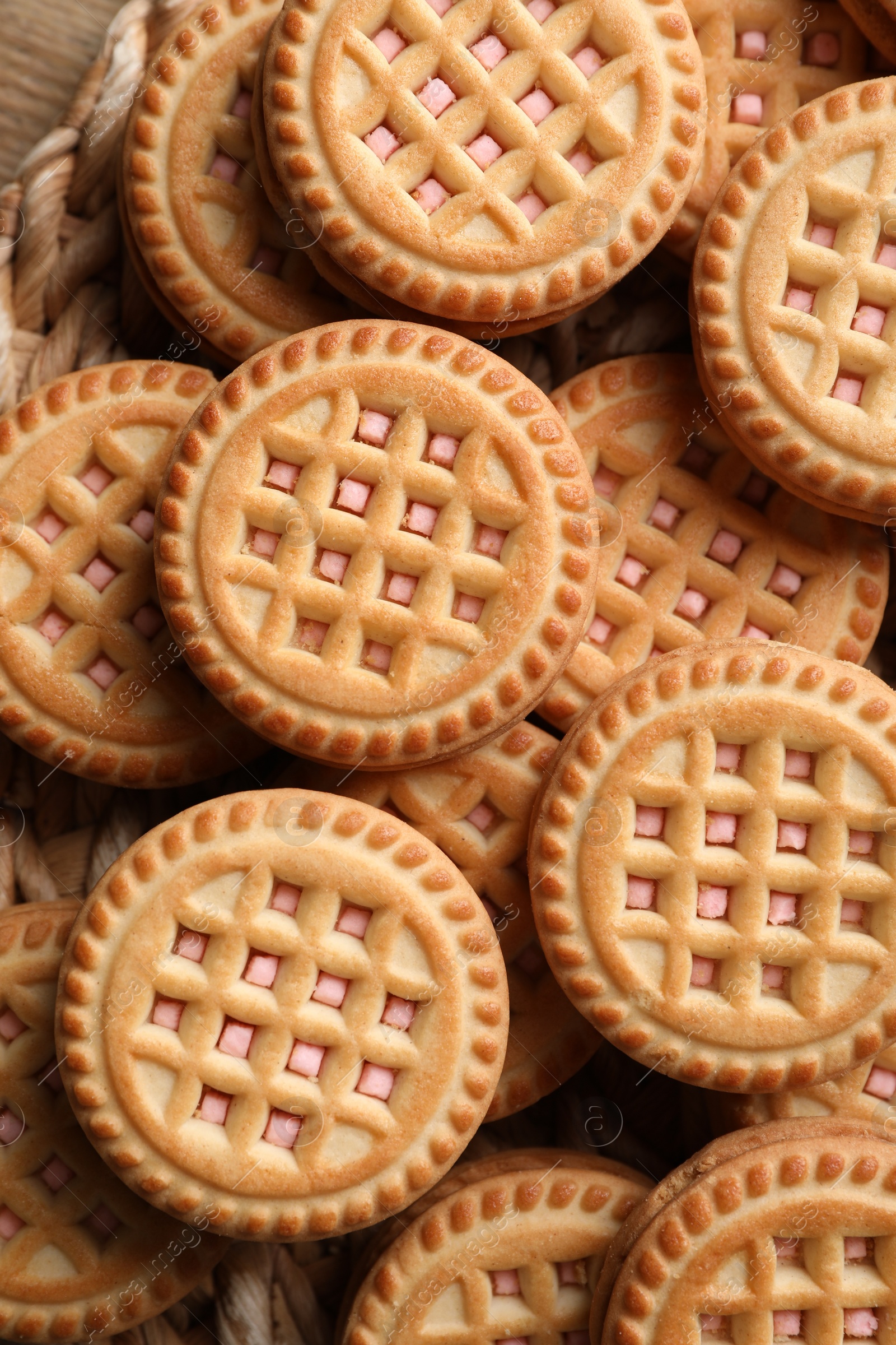 Photo of Tasty sandwich cookies with cream on wooden table, top view