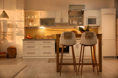 Photo of Modern kitchen interior with stylish wooden table