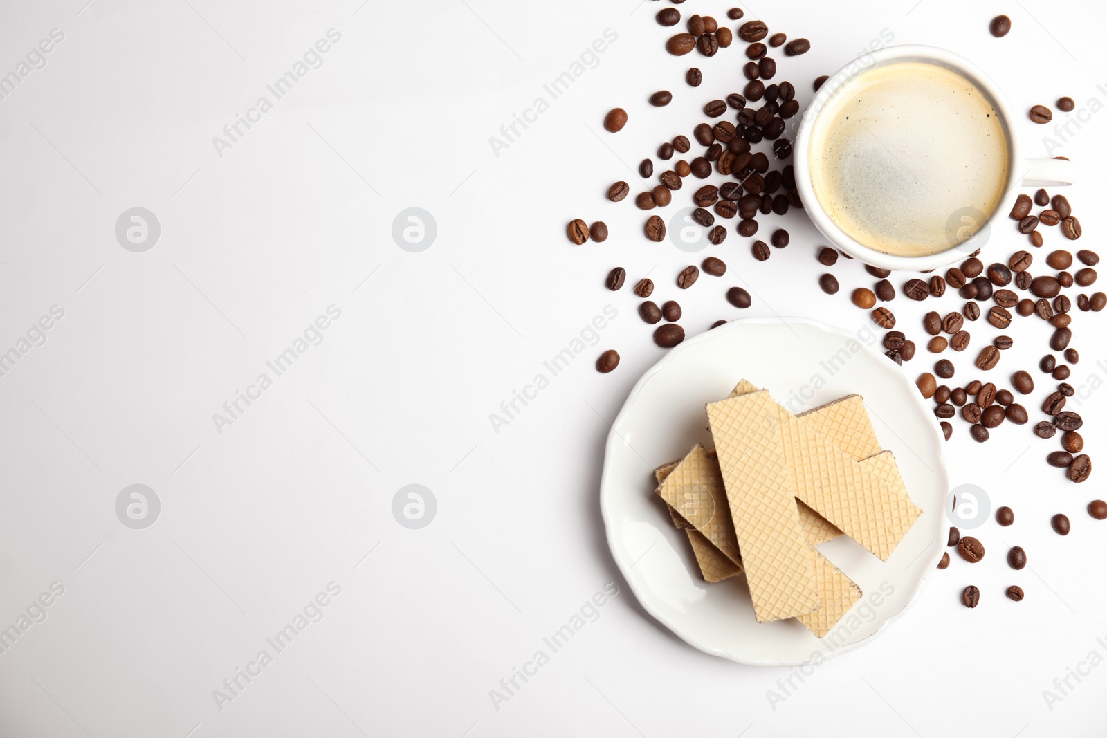 Photo of Breakfast with delicious wafers and coffee on white background, flat lay. Space for text